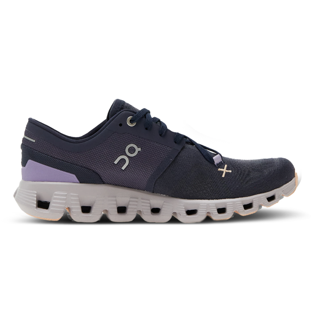 Die Laufschuhe On Running Cloud X 3 W Iron Fade sind marineblaue und lavendelfarbene athletische Laufschuhe mit einem Obermaterial aus Mesh, einer weißen, segmentierten Sohle und einem seitlichen Logo, das vom linken Profil aus gezeigt wird.