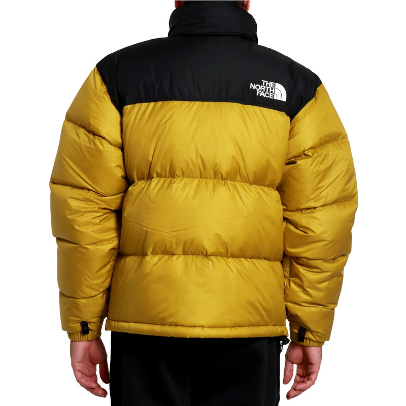Person, die die The North Face M 1996 Retro Nuptse Jacket in Deep Dijon/TNF Black trägt, von hinten gesehen, mit dem Logo auf der rechten oberen Schulter.